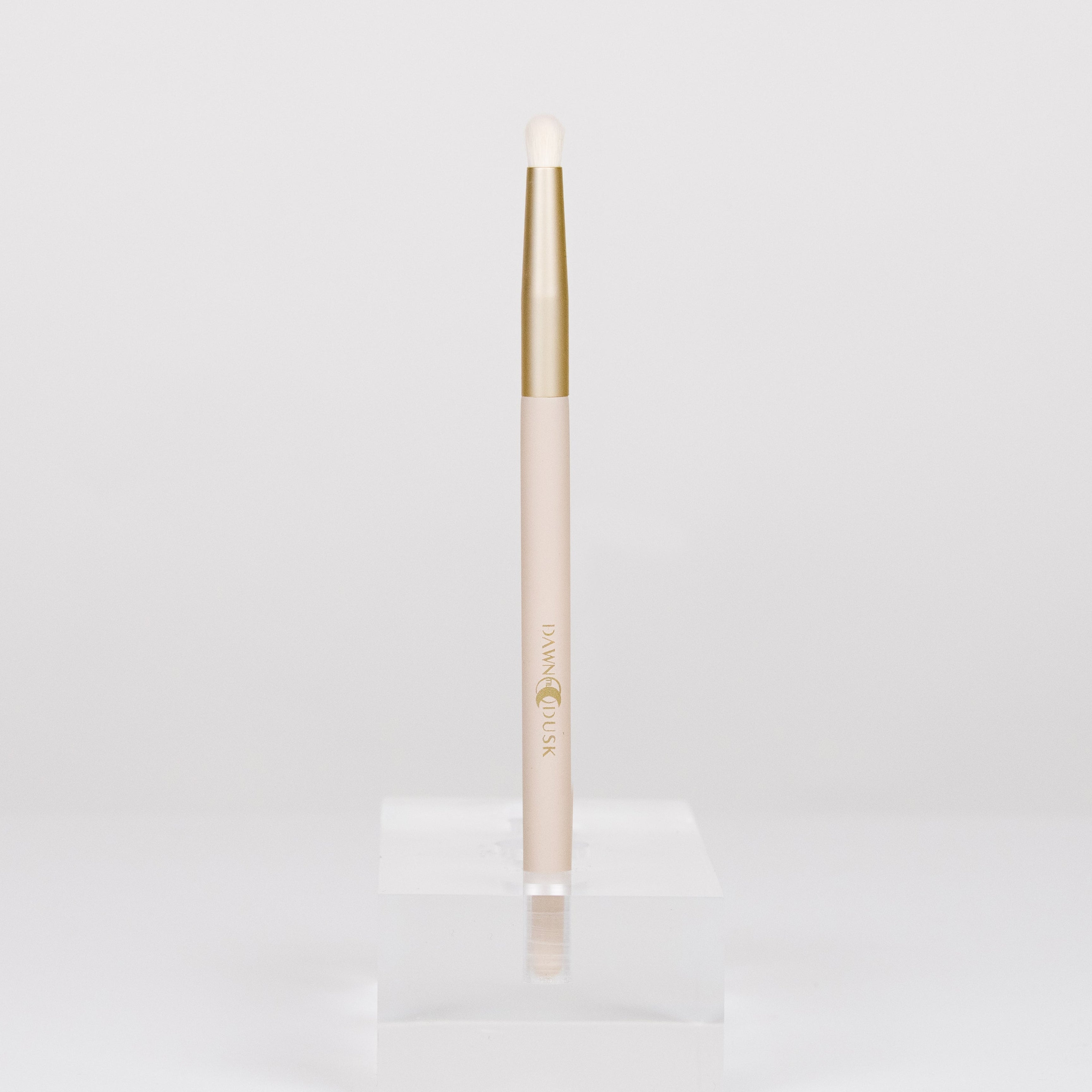Gold makeup brush on a white background