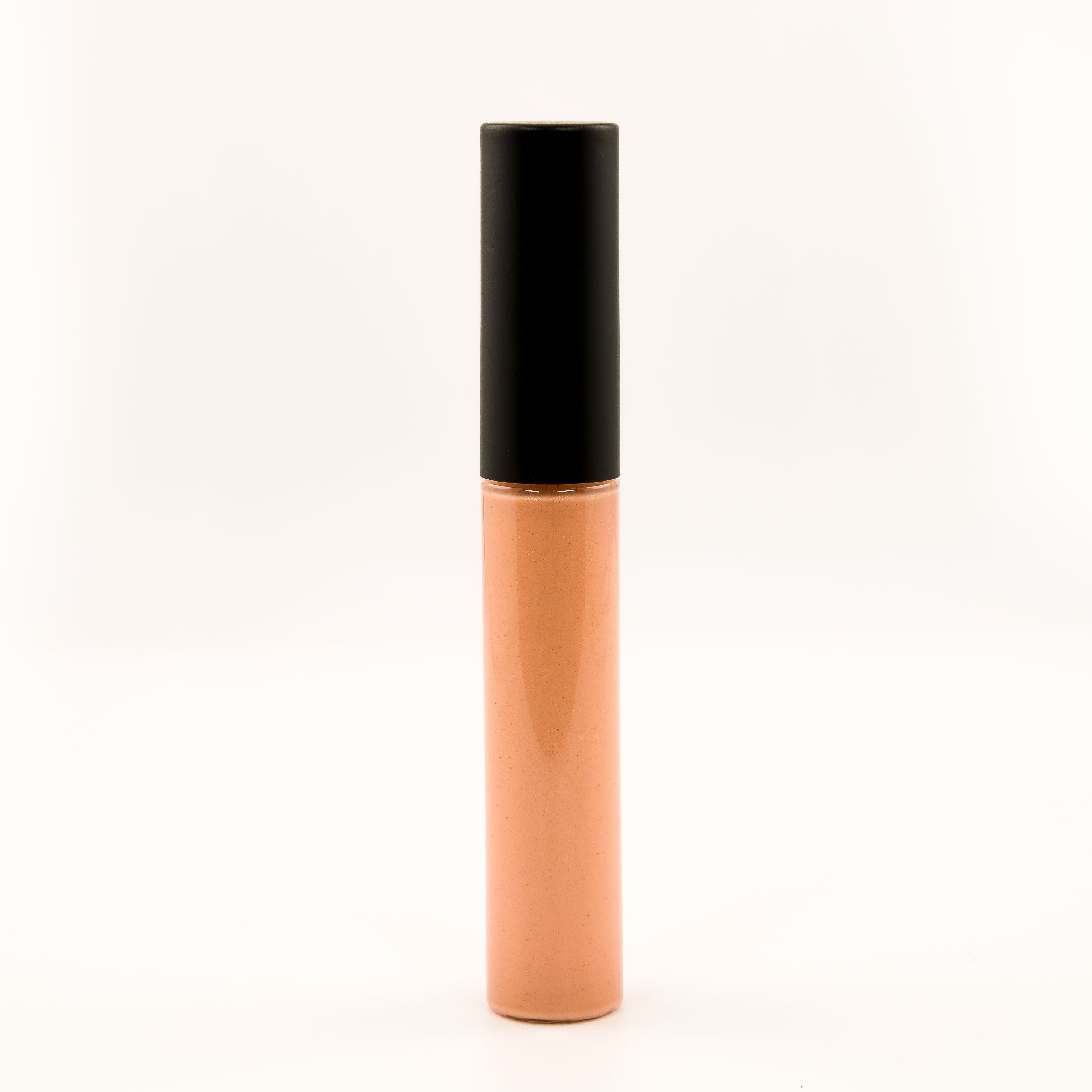 A single tube of liquid concealer or foundation standing upright on a seamless white background. The tube is a warm peach-beige shade with a glossy black cap.
