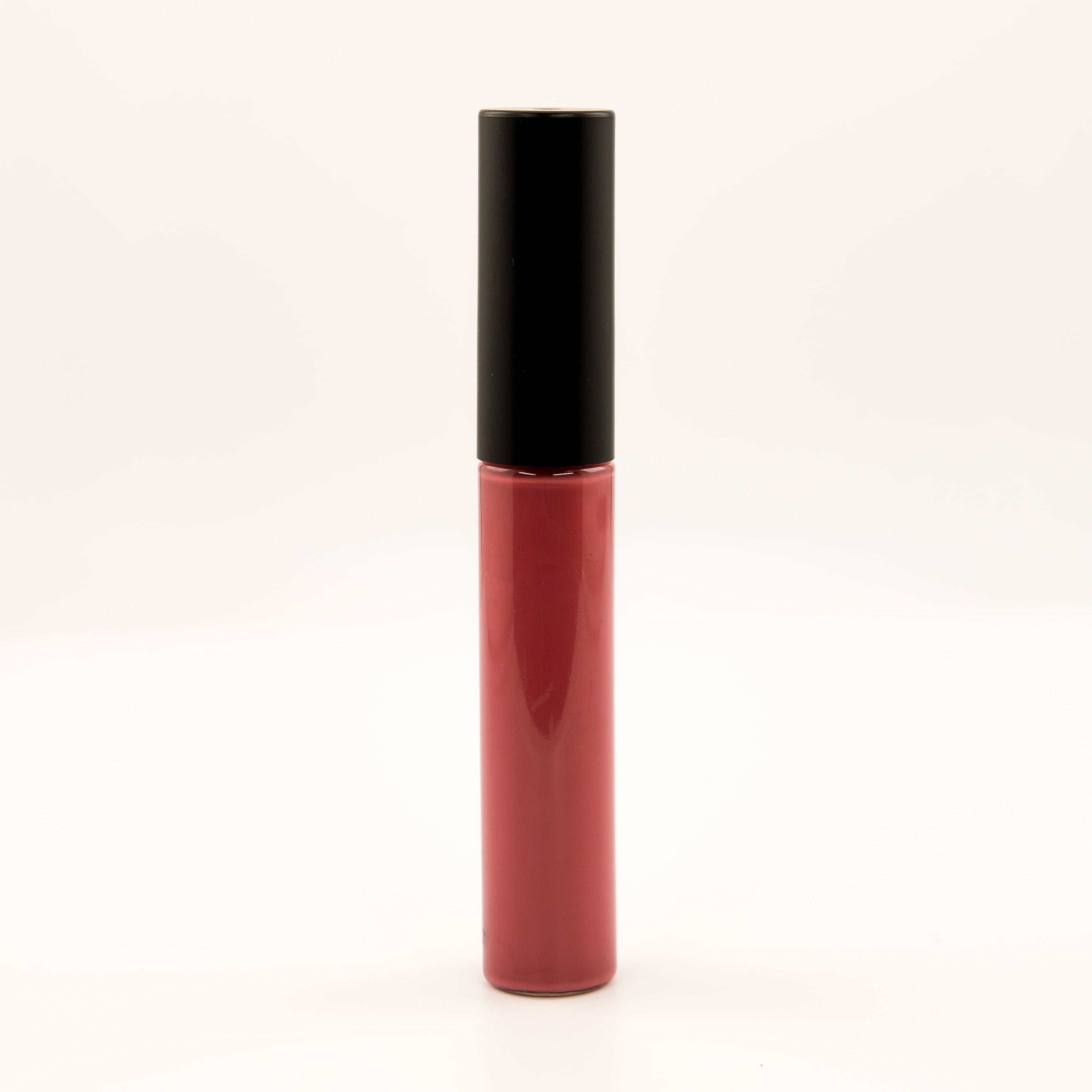 A single tube of liquid lipstick or lip gloss standing upright on a plain white background. The lower portion is a deep rosy red, and the cap is black.