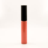 A single tube of liquid lipstick or lip gloss standing upright on a plain white background. The lower portion is a glossy coral-pink shade, and the cap is matte black.