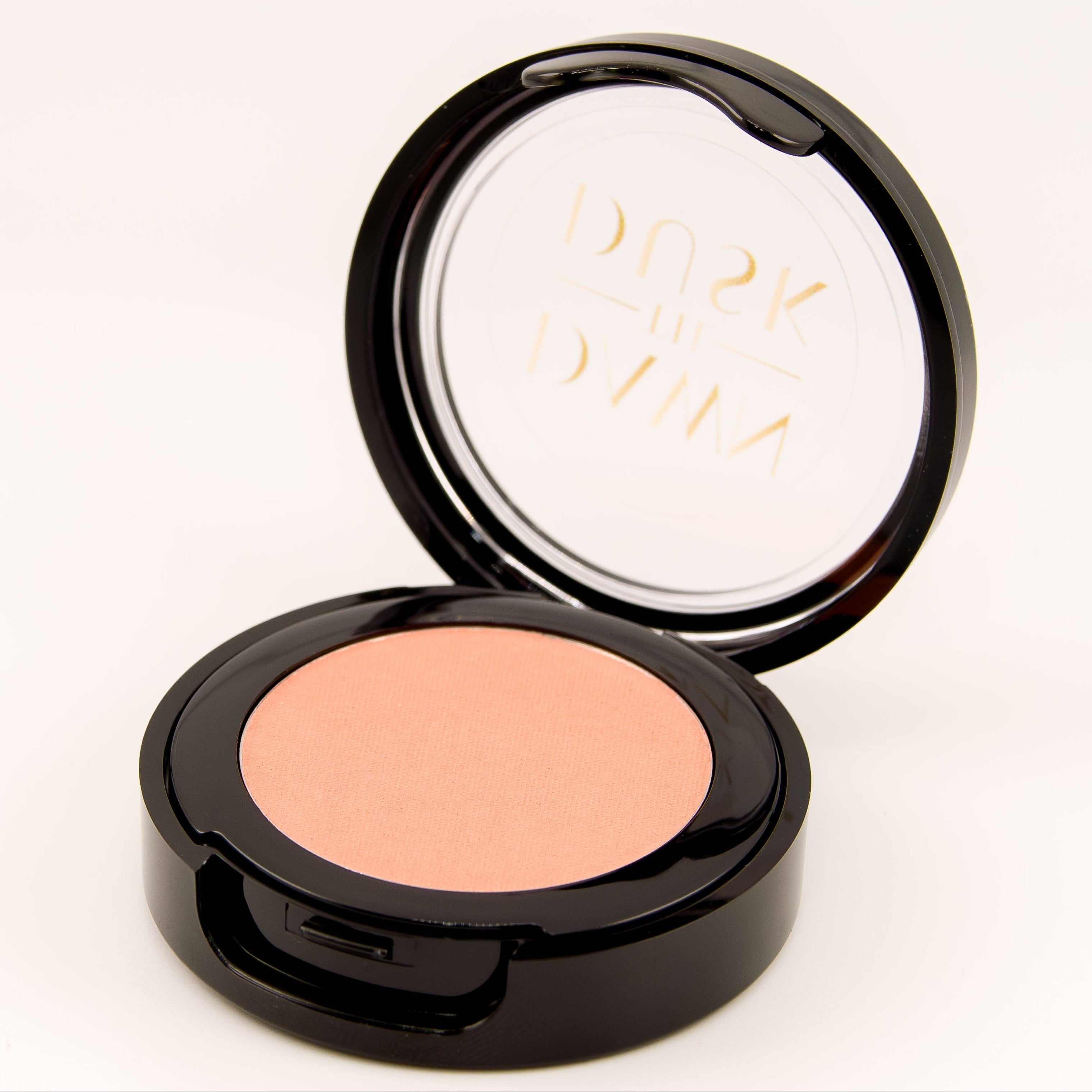 Compact blush in a black case on a white background
