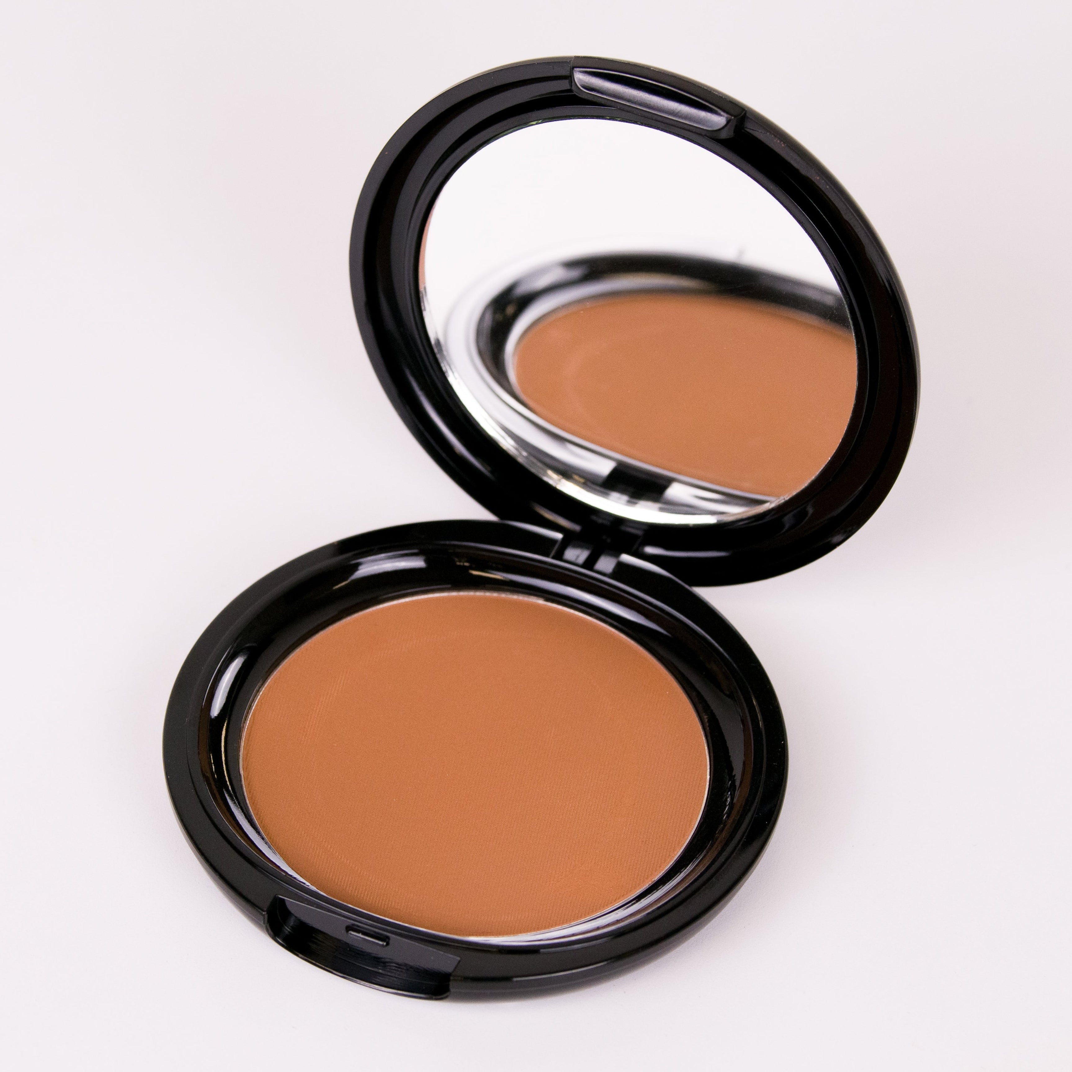 Compact powder in a black case on a white background