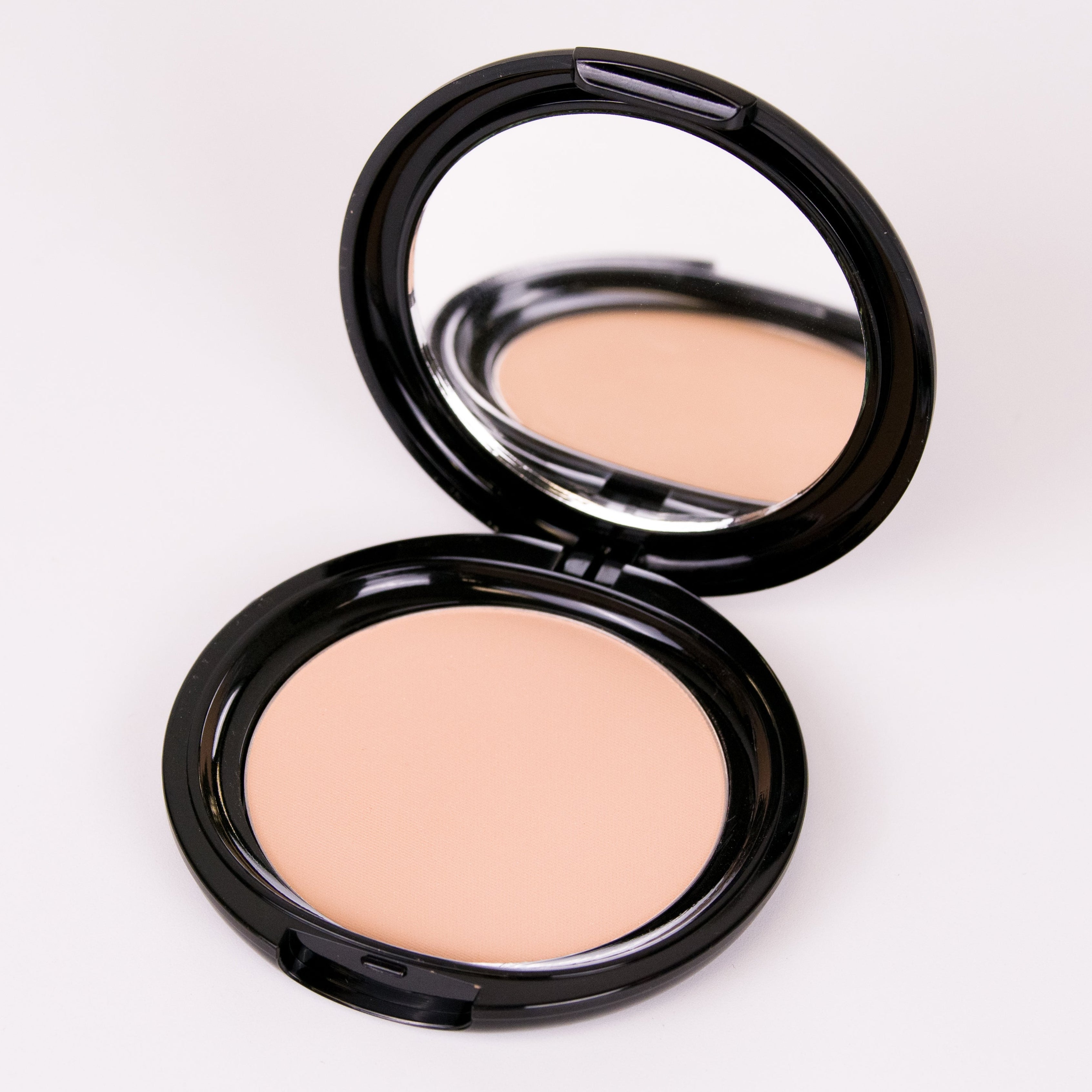 Compact powder in an open case on a white background