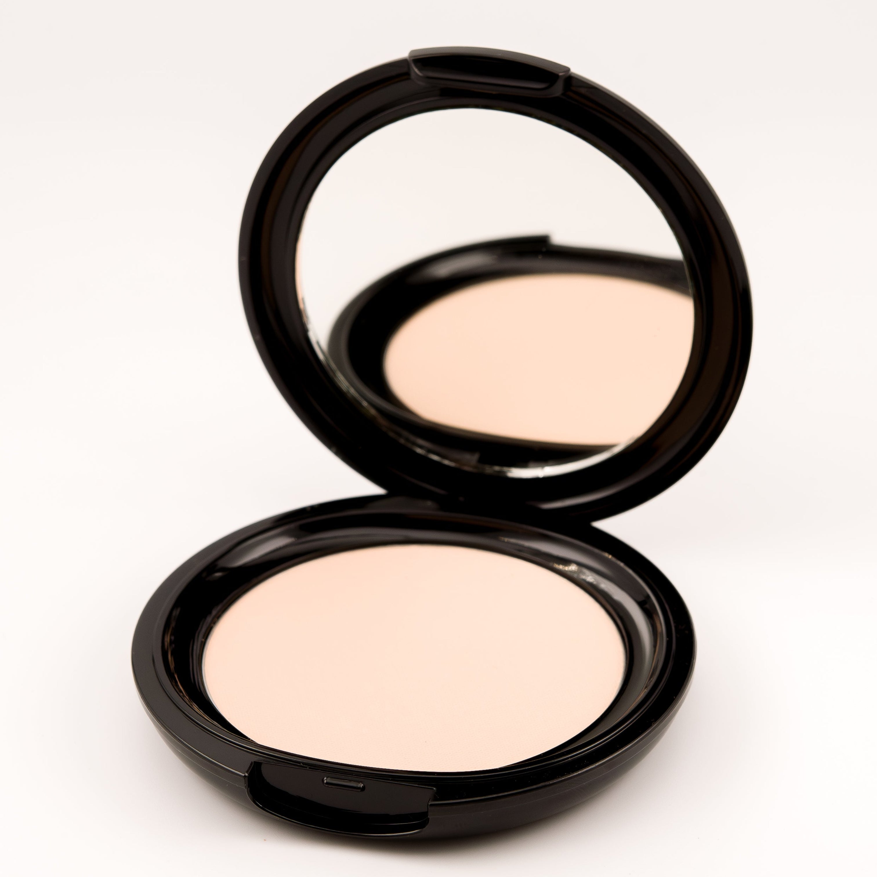 Compact powder in an open case on a white background